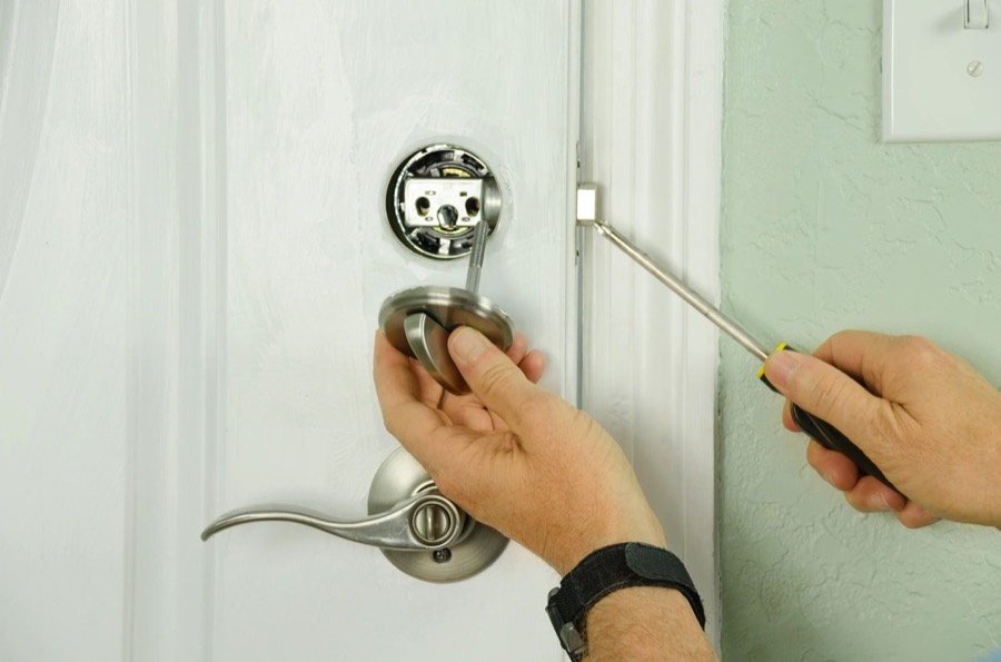 Residential locksmith installing a door lock in Aurora